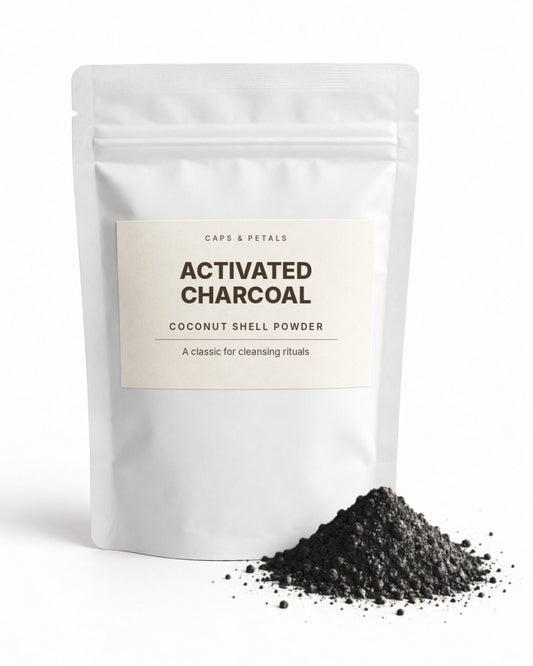 Activated Charcoal coconut shell powder by Caps & Petals in a white pouch